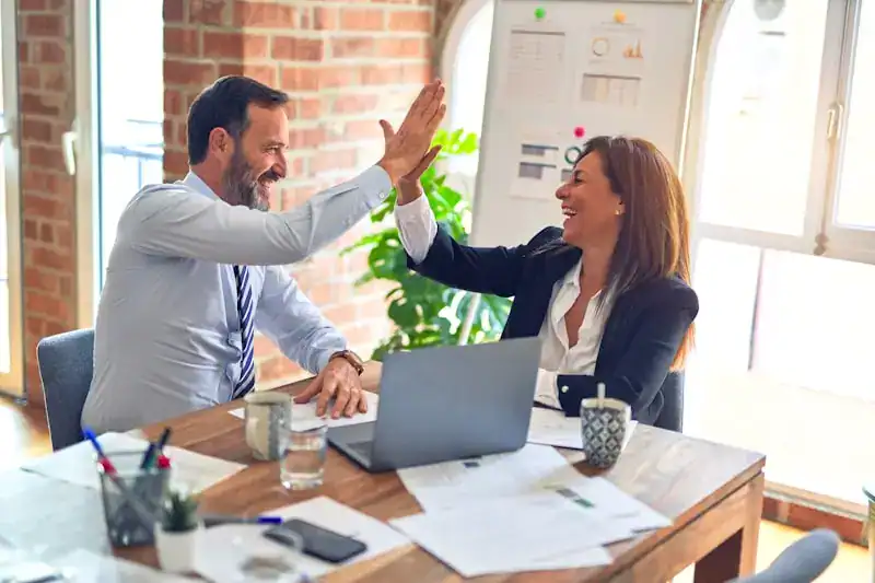 Business professionals celebrating success with virtual CFO services and financial planning.